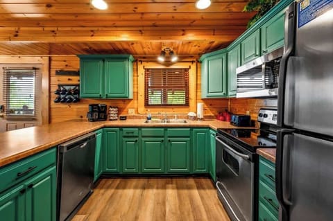 Kitchen: Vibrant teal cabinets and modern appliances make cooking a joy in this charming space!