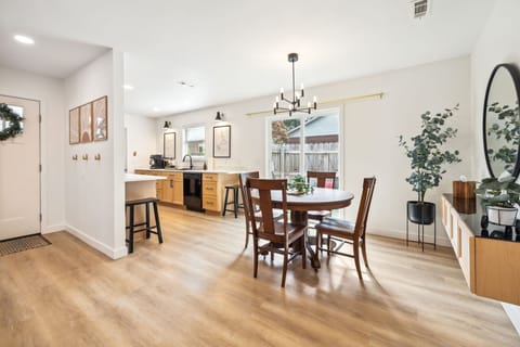 A dining table with seating for four, accompanied by two nearby bar stools for additional seating.