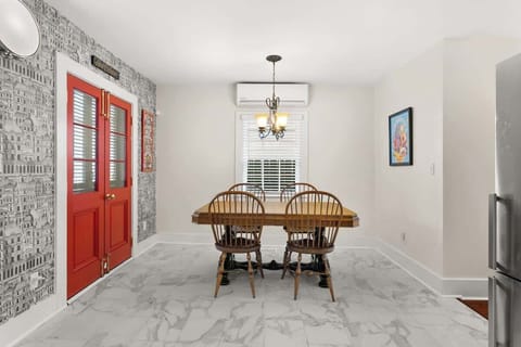 Cozy dining space with vintage table, bold red doors, and cityscape wallpaper. Perfect for relaxed meals or takeout from award-winning restaurants just steps away.