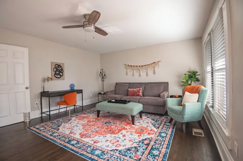 Spacious and stylish living room with vibrant decor, natural light, and ample seating.
