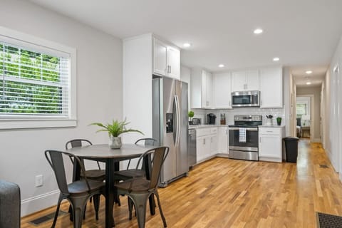 This view highlights the kitchen's expansive countertops and the adjacent dining area, emphasizing space and functionality.