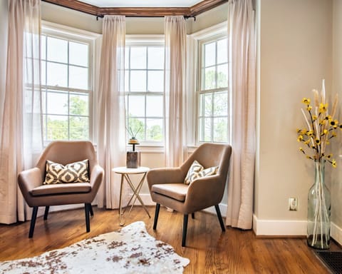 The living room features a cozy reading nook with two comfy chairs perched by the front windows. Message us about our concierge services and locally curated experiences  