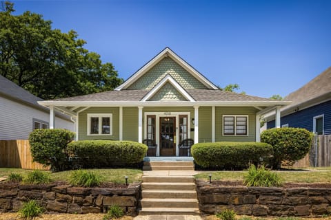 Welcome to Summer Breeze! The charming exterior of showcases its historic appeal with a welcoming front porch. The well-maintained facade and lush greenery create a picturesque and inviting entrance.