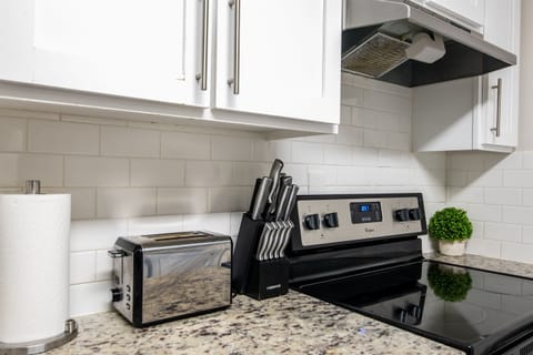 Fully equipped kitchen, including stove, microwave, toaster, and all essentials for home-cooked meals.