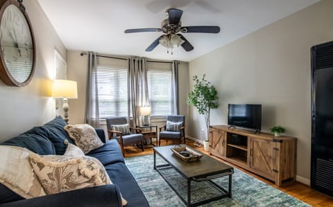 Inviting living room with plush seating, large windows, and ceiling fan—perfect for lounging or catching up on your favorite shows.