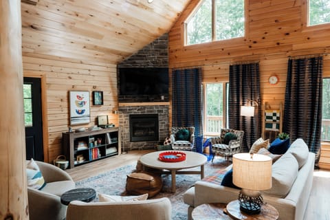 Open great room with stone fireplace and warm cabin textures