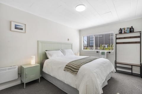 Bright, cosy bedroom with crisp white linen, wardrobe and garden views.