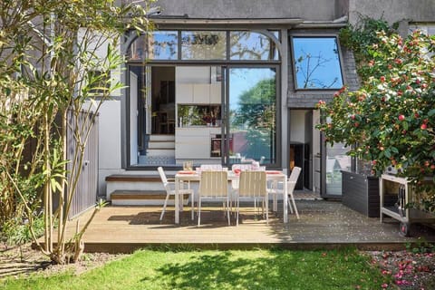 Jardin fleuri en saison avec tout le matériel pour se détendre ou profiter du grand air en déjeunant sur la terrasse (1)