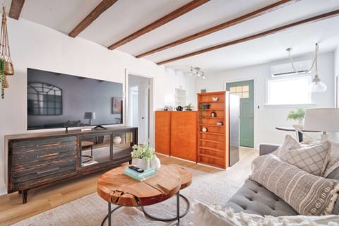 Living room with TV and kitchen beyond.