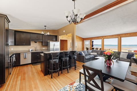 Open-concept kitchen & dining area flowing into the living room w/ lake views beyond.