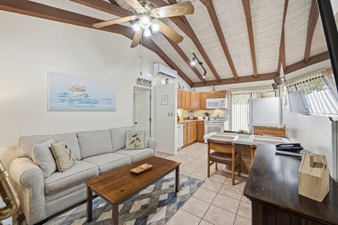 The living area offers comfortable seating, a coffee table, and an open layout that connects seamlessly to the kitchen in this 1-bedroom unit.