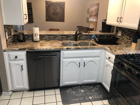 Kitchen sink, Dishwasher, gas stove, granite counter-tops, stocked for cooking.