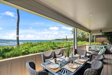 Oceanfront dining on a covered lanai with stunning views of the Pacific and lush tropical greenery