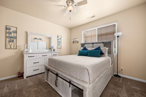 Primary bedroom offers a comfortable queen bed, an attached bath, a smart TV, and clothing storage.