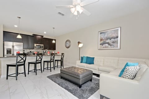 Bright & Stylish Living Room – Unwind in this inviting living room with plush seating, a large TV, and an open layout that connects seamlessly to the dining and kitchen areas.