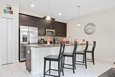 Modern Open-Concept Kitchen – A fully equipped kitchen with sleek black cabinetry, stainless steel appliances, and a spacious island, perfect for preparing meals and gathering with loved ones.
