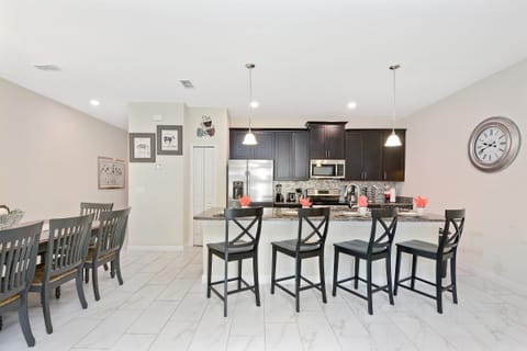 Modern Open-Concept Kitchen – A fully equipped kitchen with sleek black cabinetry, stainless steel appliances, and a spacious island, perfect for preparing meals and gathering with loved ones.