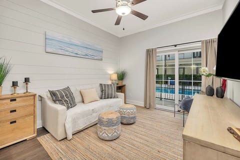 Living room with shiplap wall and patio overlooking pool.