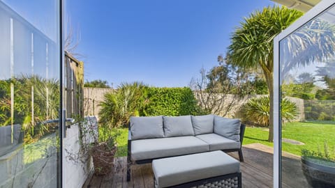 The private, fully enclosed rear patio features comfortable outdoor lounge furniture, perfect for relaxing.