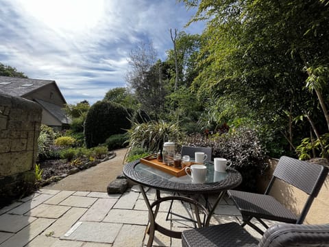 Unwind in a charming garden oasis, where vibrant flowers and leafy bushes create a perfect spot to sip your morning coffee or enjoy a quiet evening