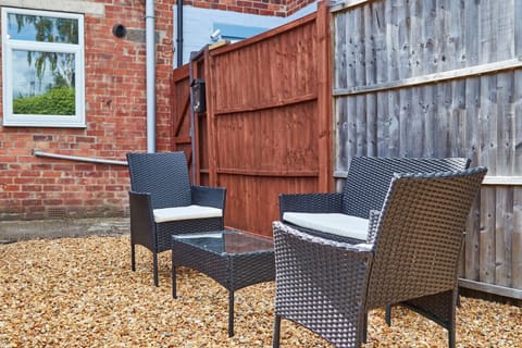 Fully fenced garden with outdoor seating.