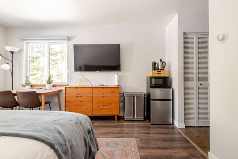 Cozy bed with rave reviews, forest views, desk with natural light, smart TV, and kitchenette—perfect for peaceful workdays and relaxing nights.