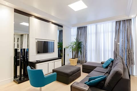 Sala ampla com sofá grande e TV, espaço de sobra pra todo grupo curtir junto