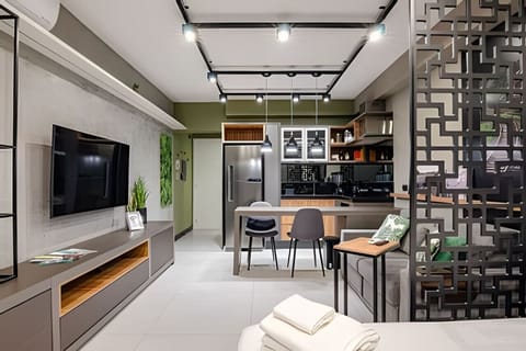 Sala - Televisão, balcão 2 cadeiras, sofá 2 lugares e mesa de apoio.