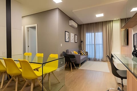 Sala espaçosa com ar condicionado, mesa de estudos/leitura, televisão, sofá 2 lugares e mesa 6 cadeiras.