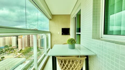 Sacada com vista para cidade, verde nas paredes e plantas