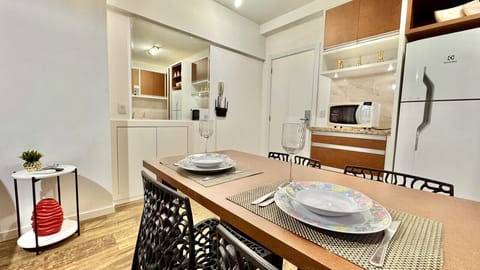 Cozinha compacta com geladeira branca, bancada e cooktop integrados