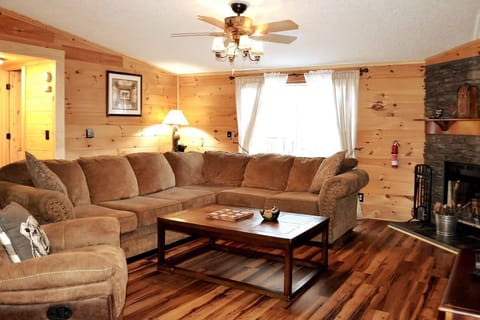Cozy spot with soft seating, a rustic wood wall, and warm glow that feels just like home.