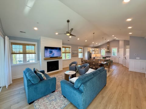 Living room with cathedral ceiling looking into dining area
