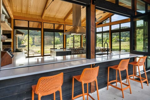Modern chef's kitchen with panoramic views and bar seating-ideal for cooking and connecting in a stunning setting.