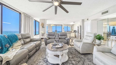 Spacious open-concept living with leather seating, Gulf views, and easy flow to kitchen and dining—ideal for relaxing or entertaining.