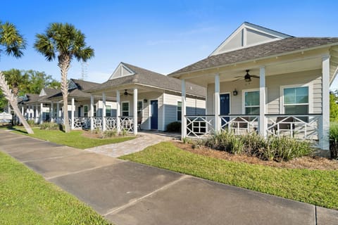 Charming coastal-style buildings with tropical palm trees and landscaped grounds create a welcoming resort atmosphere.