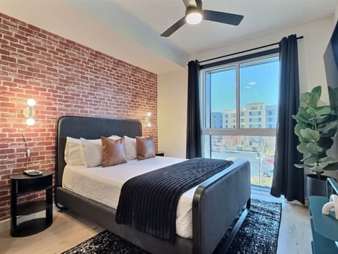 Relax in a cozy bedroom with city views inside a furnished apartment.