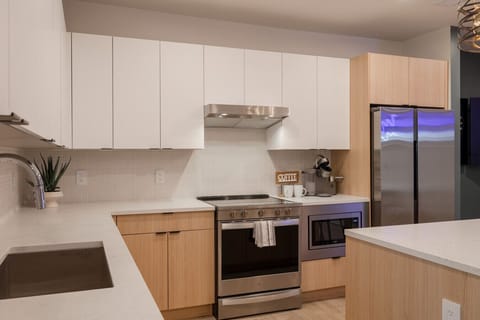 Stylish and functional kitchen with sleek white cabinetry, stainless steel appliances, and natural wood accents.