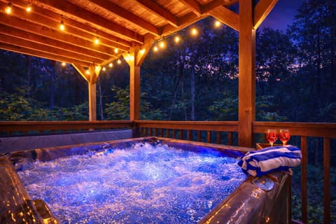 Soak under the trees in your private hot tub retreat—complete with twinkling string lights, bubbling warmth, and a forest backdrop made for unwinding.