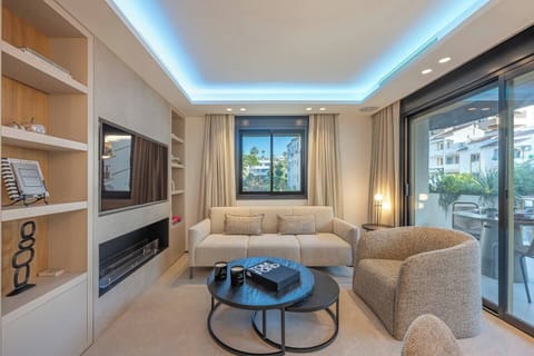 Enjoy comfort and elegance. Relax on the sofa or armchair with warm ambient lighting and a fireplace. A sophisticated space that invites relaxation and opens onto the terrace to connect with the outdoors, creating a serene and welcoming atmosphere.