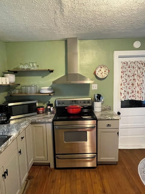 Stove, coffee maker, microwave, and fully stocked kitchen.