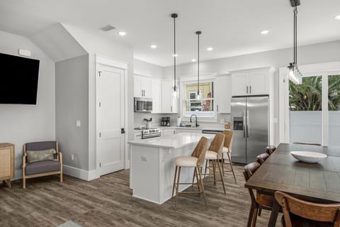 Sleek kitchen with island seating, stainless steel appliances, and a spacious dining area.