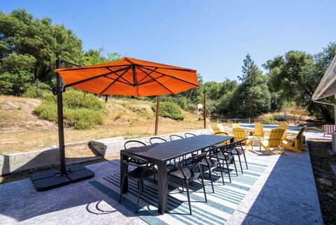 Complete with a vibrant orange offset umbrella and a spacious dining area, this outdoor oasis invites endless relaxation & unforgettable gatherings under the sun. Whether it's a leisurely brunch or a starlit dinner, this inviting space is ready for you!