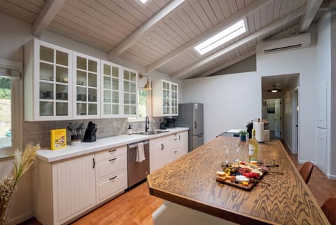 Spacious kitchen with an island irresistible to gather around. Two stools offer additional seating in the dining area. Fully stocked coffee bar with pourover, drip, k-cup, smart kettle, toaster, tea, coffee, sugar, creamer