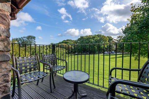 Patio with outdoor seating overlooking green fields.