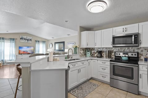 Open-concept kitchen equipped with modern appliances and countertop seating, perfect for cooking and gathering with family and friends.