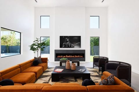 Unit 2: Professionally and intricately designed modern styled living area with large hand-painted mural, 20 ft vaulted ceilings, large electric fireplace, large smart TV, and complete with designer furnishings.