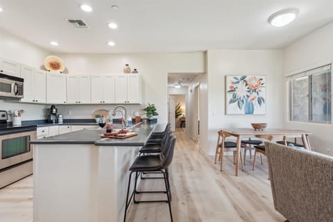 The Kitchen showcases a clean look, stainless steel appliances, and bar seating for four in a stylish, functional layout.