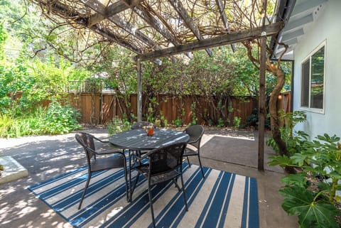 Outdoor dining is a joy under the cool shade of - the wisteria vine.