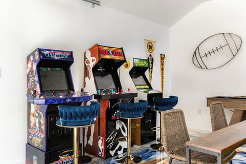 Game room with Golden Tee, NFL Blitz, NBA Jam, big screen tv, and shuffleboard